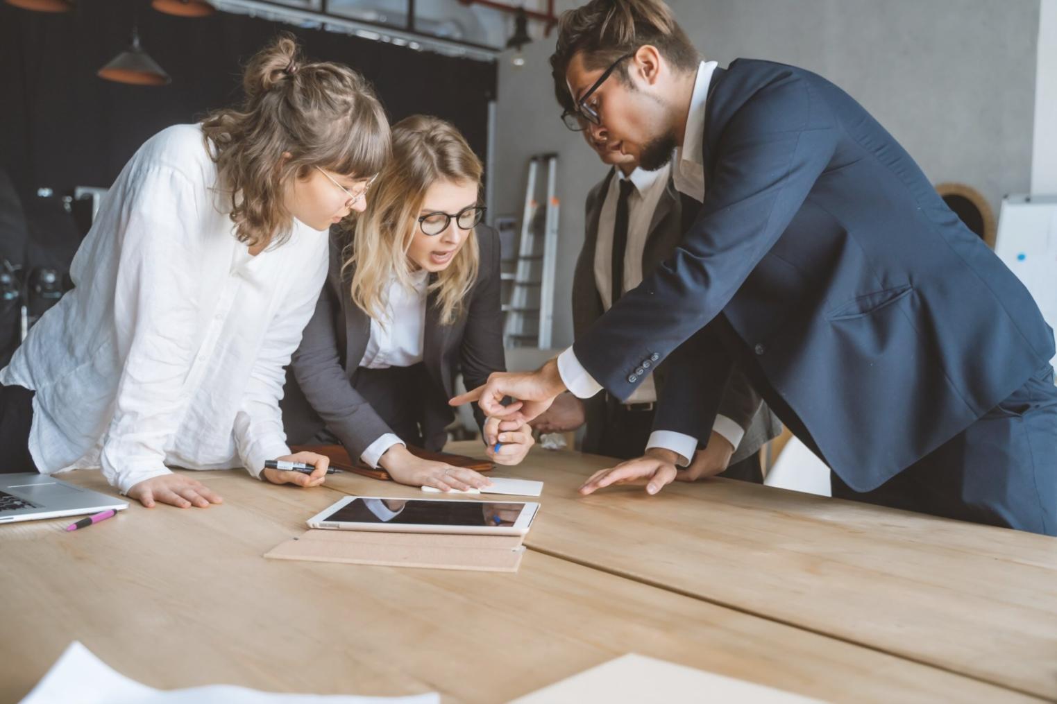 Equipo de profesionales colaborando en análisis financiero con documentos y gráficos